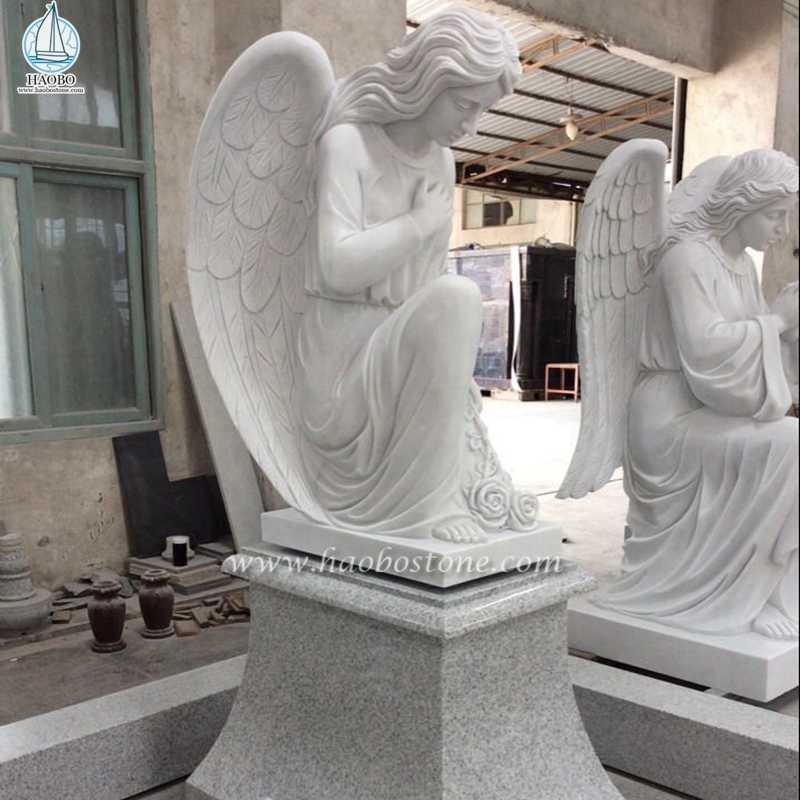 記念のための白い大理石のひざまずく祈りの天使像
