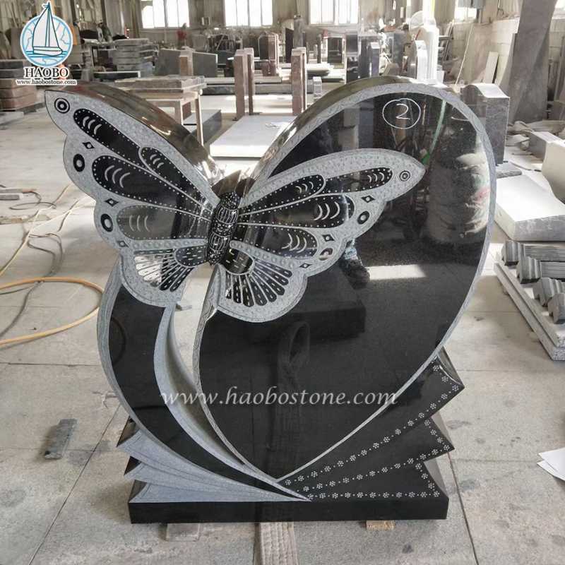 黒御影石のハートに蝶の彫刻が施された記念の墓石
